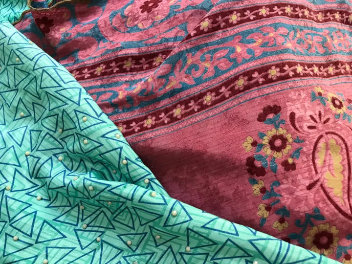 Two colorful fabrics, one green with geometric shapes, the other pink with floral designs