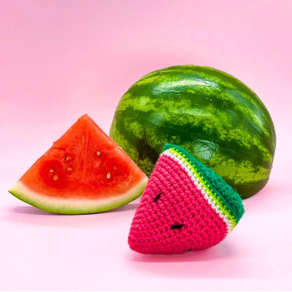 A vibrant scene featuring a watermelon, a fresh slice, and a crocheted watermelon piece.