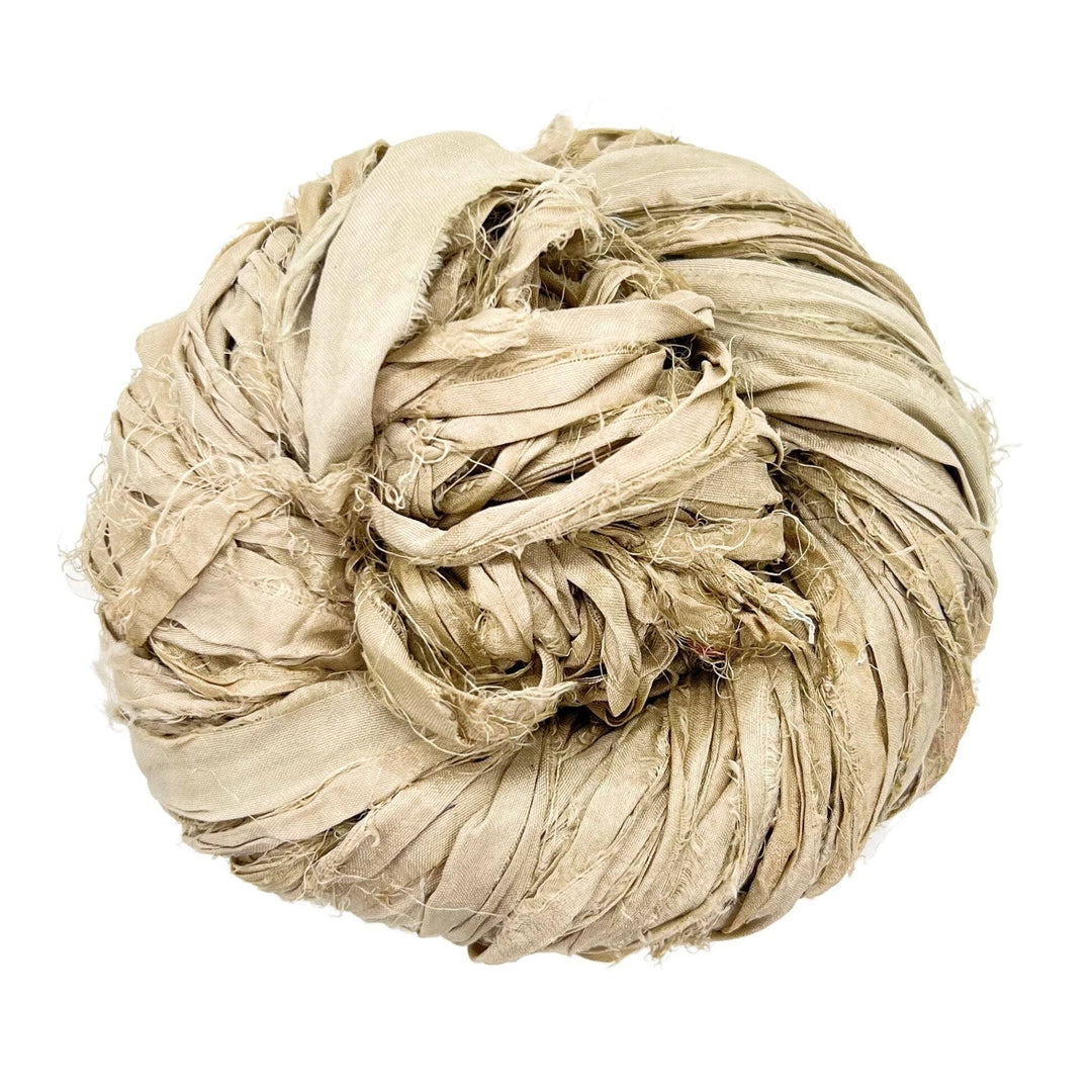 A large ball of beige frayed fabric strips coiled together.