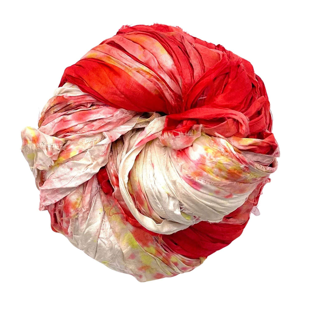 Tightly wrapped tie-dyed fabric bundle in red, white, and yellow on a white background.