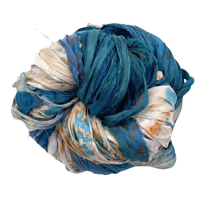 A ball of tie-dyed fabric strips with blue and white patterns.